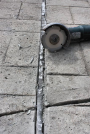 Stellit-Cutter:  Sealant sliced on both insides edges of concrete control joint.